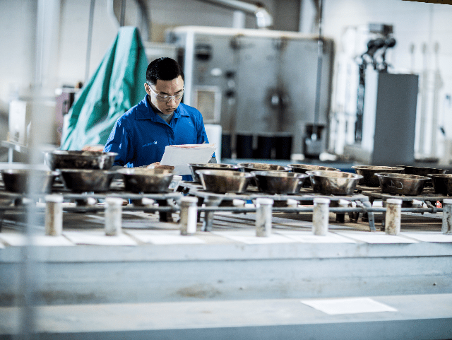 Man in laboratory exa矿业 soil boring samples in a row of metal containers